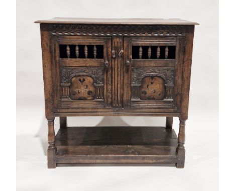 18th century oak dole cupboard, the two cupboard doors with turned spindle sections, carved and inlaid foliate decoration to 
