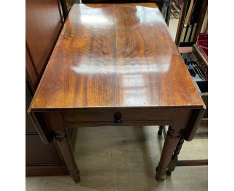 A Victorian mahogany Pembroke table, the rectangular top with drop flaps and a frieze drawer on ring turned tapering legs and