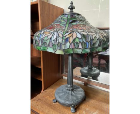 A Tiffany style table lamp, the domed glass shade decorated with flowers and leaves above a tapering stem and spreading base 