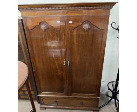 A 20th century mahogany wardrobe, with a moulded dentil cornice above a pair of cupboard doors and a base drawer on bracket f