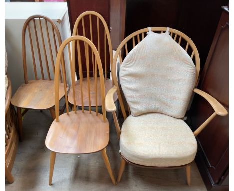 An Ercol elbow chair together with a set of three spindle back dining chairs