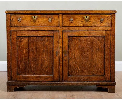 A 19th century oak side cabinet, the two drawers with ring handles over panelled doors and on bracket feet, 126cm wide x 46cm