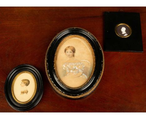 A watercolour portrait miniature painting on paper in a gilt and black painted wooden frame depiciting a young woman, signed 