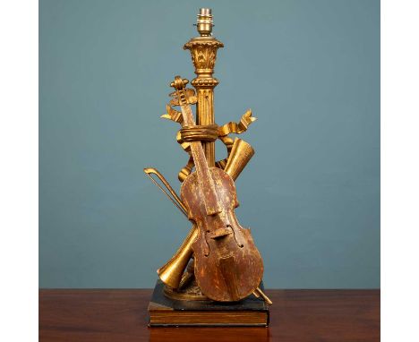 A carved giltwood and red painted finish lamp stand with a violin design on a reeded column with scrolling floral detail, on 