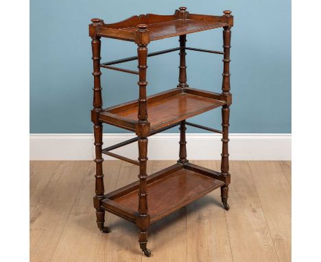 A Victorian mahogany what-not with three tiers and carved supports all standing on brass castors, 63cm wide x 31.5cm deep x 9