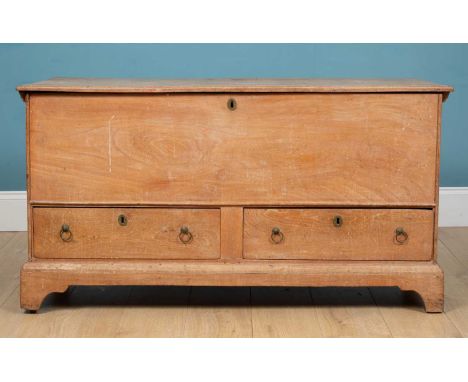 An early 19th century elm mule chest, the lifting lid with plain interior over drawers with ring handles and on bracket feet,