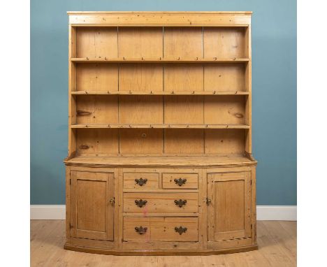 A 19th century pine dresser, the three shelf plate rack over bow fronted base with four various drawers flanking curving pane