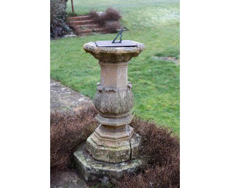 A Regency Coade stone sundial of octagonal form with slate dial and a bronze gnomon, the upper surface decorated with masks, 