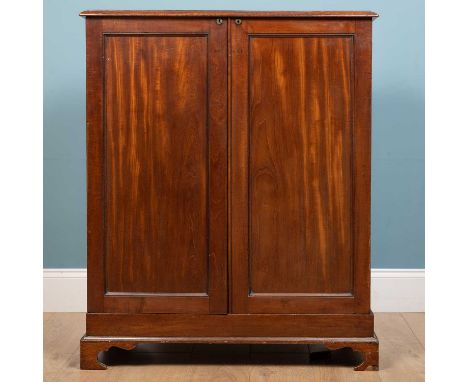 A 19th century mahogany campaign type gentleman's dressing cabinet the lifting lid with adjustable mirror, the panelled doors