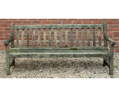 A teak garden bench, 183cm wide x 66cm deep x 83cm highWeathered condition overall. Some repair needed to the joints, particu