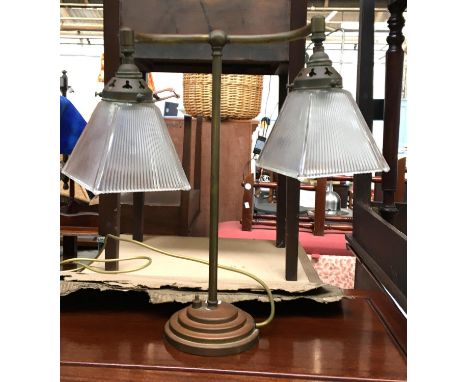 An Art Deco brass table lamp, the twin fittings each with glass shade, on a stepped circular base, 44cmH 