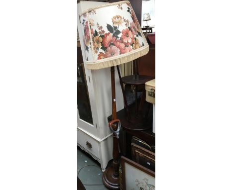 A turned wooden standard lamp with floral shade 