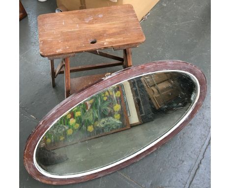 An oval wall mirror with bevelled glass, overall dimensions 87.5x48cm; together with a wooden step ladder (af) 