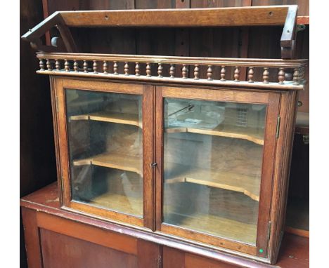 A small oak glazed hanging shelf, with bracket, the doors with bevelled glass, opening to reveal two shelves, 81cmW 