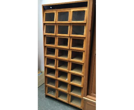 A 20th century light oak haberdashery retailers shirt display unit, with 24 glazed sliding drawers, 91.5x50.5x199cmH 
