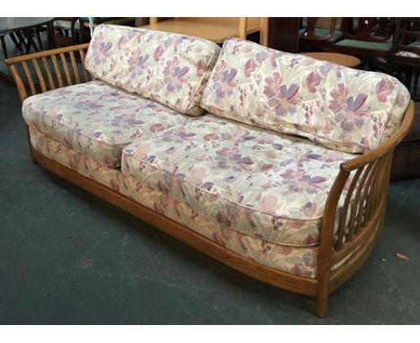 An Ercol Renaissance light oak three seater latheback, upholstered in a pastel floral fabric, approx. 220cmW 