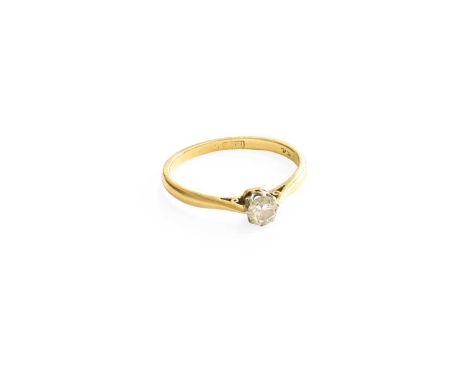A Diamond Solitare Ring, the round brilliant cut diamond in a white claw setting, to a yellow tapered shoulder plain polished