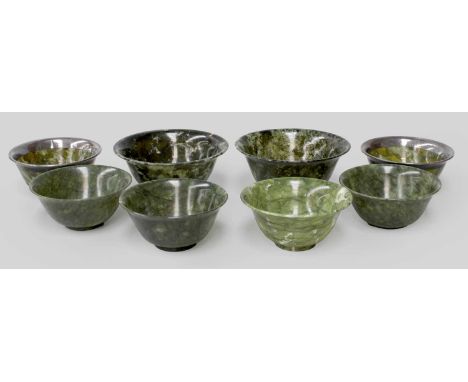 Eight Chinese Jade Bowls, various colours and sizes, with everted rims and footed bases, including a pair of spinach jade exa