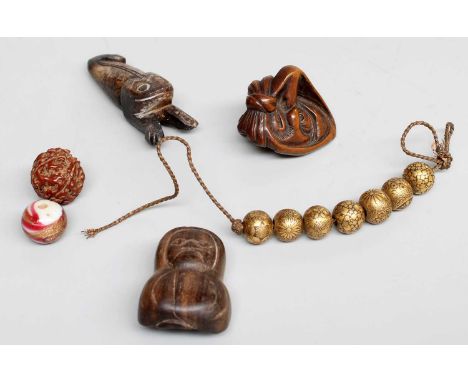 A Japanese Carved Wooden Netsuke of a Daruma Doll, with unhappy expression, 4cm high; together with a nfurther figural wooden