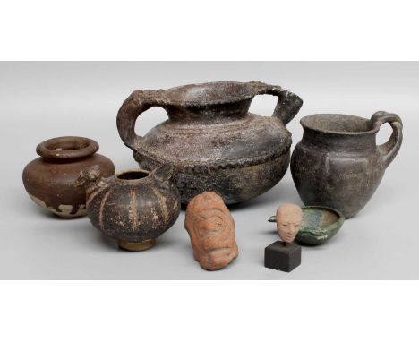 An Etruscan Bucchero Ware Pot, circa 700-600 B.C. of baluster form, everted rim, crossover loop handle, ribbed body, 10cm hig