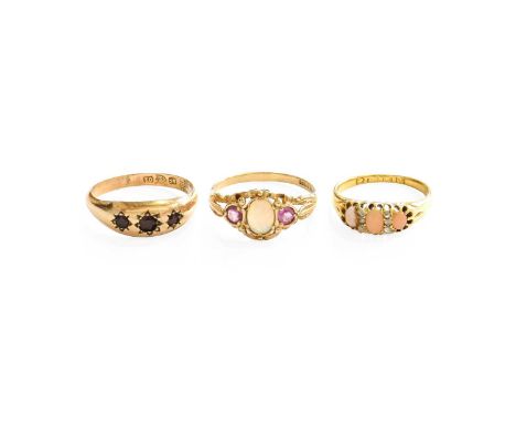 An 18 Carat Gold Coral and Diamond Ring, finger size N (a.f.); A 9 Carat Gold Opal Ring, finger size S; and A Garnet Three St