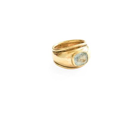 A 9 Carat Gold Aquamarine Ring, the cushion cut aquamarine in yellow rubbed over setting, to a broad tapered shank, finger si