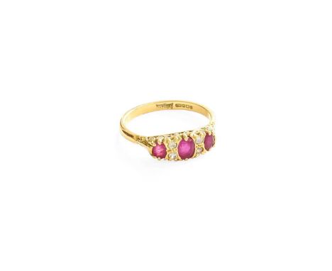An 18 Carat Gold Ruby and Diamond Ring, three graduated oval cut rubies spaced by pairs of round brilliant cut diamonds in ye