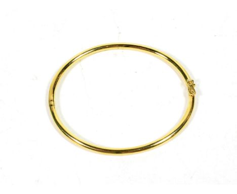 An 18 carat gold hinged bangle, inner measurements 6cm by 5.3cm .  Gross weight - 22.24 grams. 