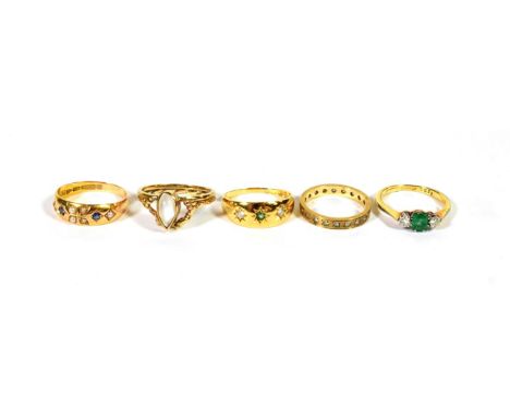 A 9 carat gold moonstone ring, finger size K1/2; a 9 carat gold paste set eternity ring, finger size I; an emerald and diamon