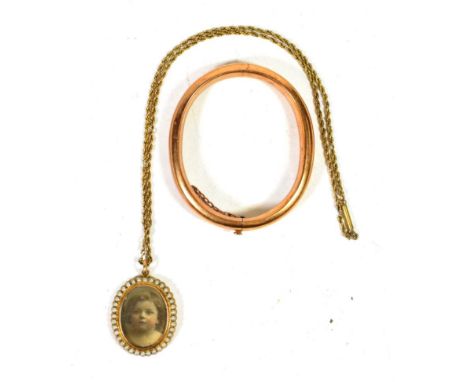 A stiff hinge bangle, stamped '15'; together with a locket, stamped '15' on chain (2).  Bangle gross weight - 19.35 grams. Lo