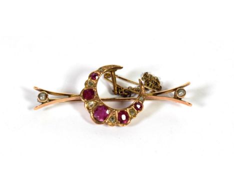 A ruby, diamond and pearl crescent brooch, the graduated oval rubies alternate with old cut diamonds, in yellow claws to form