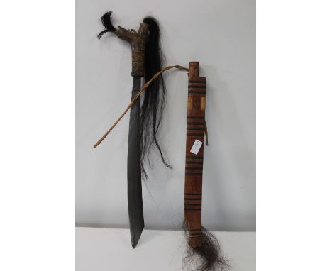 An unusual tribal machete in a wooden scabbard 