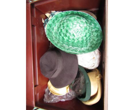 A bygone tin trunk containing 1940's, 50's and 60's fashion hats in various materials and colours 