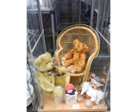 A cane chair for a doll or teddy bear and a collection of teddy bears. 