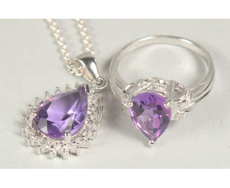 A silver amethyst and diamond pendant chain and ring in a box.