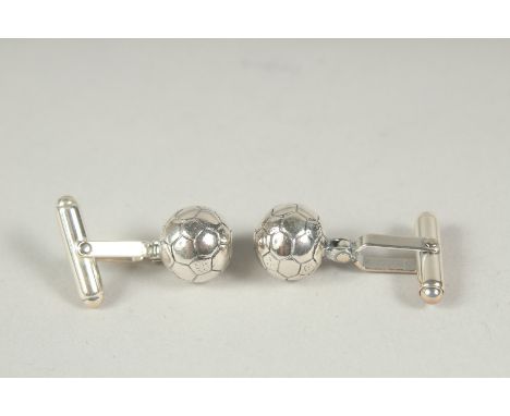 A pair of silver football cufflinks.