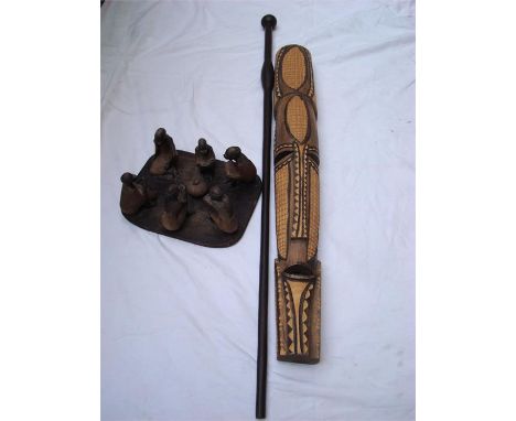 An African wall mask together with a stick and a carved figure group of men sitting round a pot (3). 