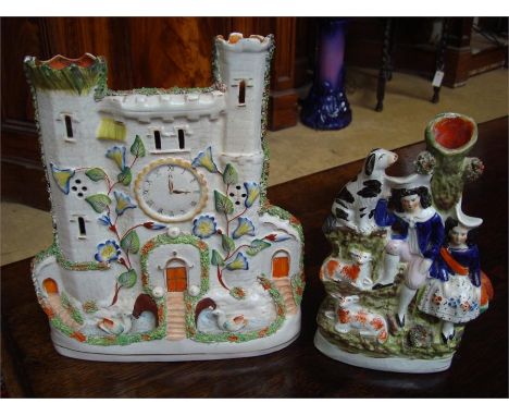 A Staffordshire model in the form of a clock tower, 29cm high together with a Staffordshire model in the form of two figures 