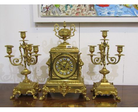 FRENCH CLOCK GARNITURE, 19th Century ornate brass cased mantel clock with pedestal urn pediment and twin lion mask ring drop 