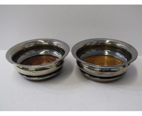 SILVER DECANTER COASTERS, with turned hardwood bases, a matched pair, one HM Sheffield 1973, other Birmingham 1973 