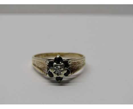 9CT YELLOW GOLD SAPPHIRE &amp; DIAMOND CLUSTER RING, principal illusion set diamond surrounded by 6 dark blue sapphires in 9c