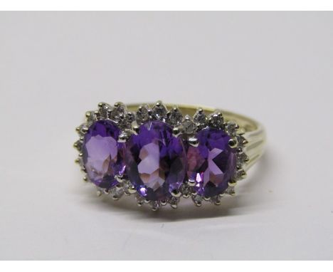 9CT YELLOW GOLD AMETHYST &amp; DIAMOND CLUSTER RING, 3 principal oval cut amethysts surrounded by a cloud halo of accent bril