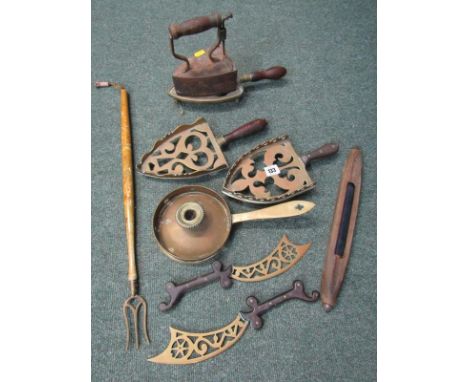 METALWARE, antique box iron, 3 ornamental brass trivets, brass chamber stick, toasting fork and contents of shelf 