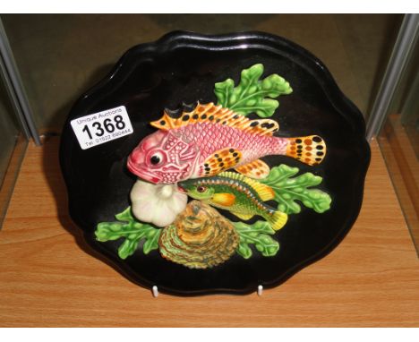 A ceramic wall plaque depicting fish and shell fish.
