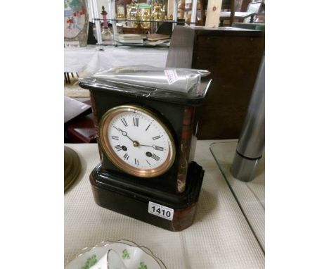 A marble mantel clock with key and pendulum.