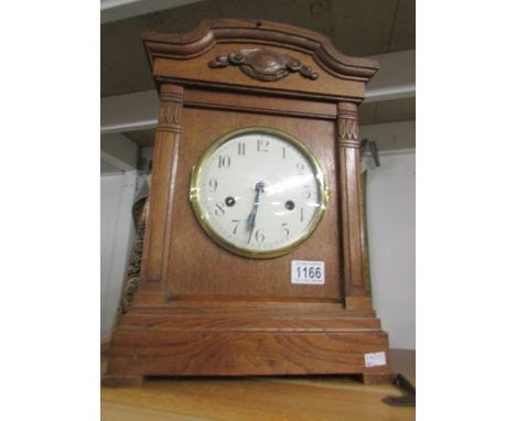 An Edwardian oak cased mantel clock with Westminster chime including key and pendulum, in working order.