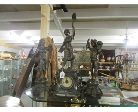 A spelter 3 piece clock garniture surmounted figures.