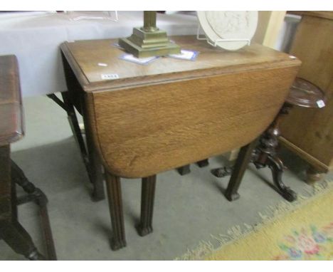 An oak gate leg table on square reeded legs.