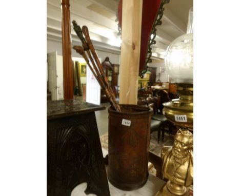 A leather stick stand and 3 walking sticks.