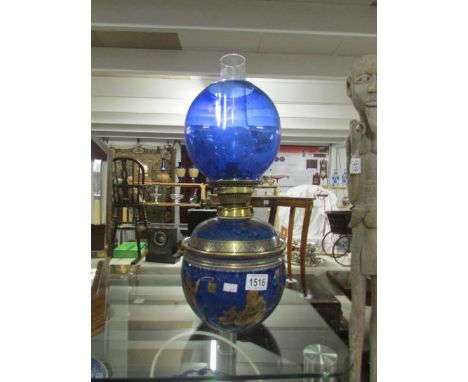 A Chinese blue oil lamp with blue shade.